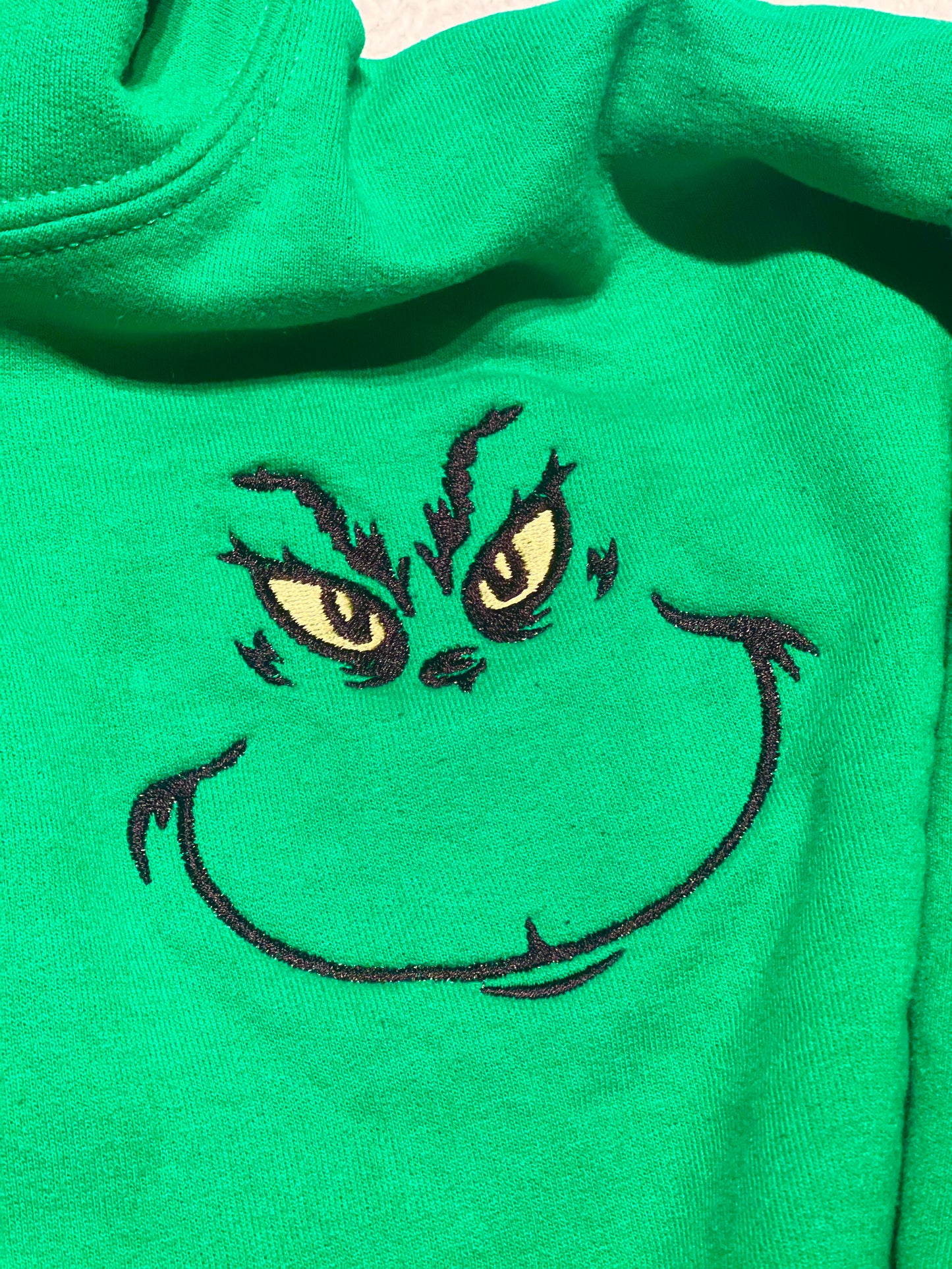 Grinch face hoodie close‑up of print